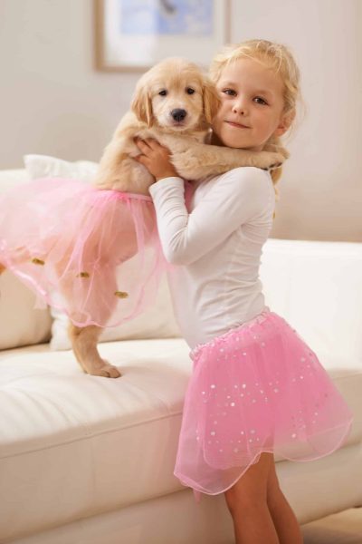 Dont we look like twins. A little girl dressing her puppy in a tutu